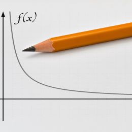 curved graph showing decreasing trend with a pencil on top of it
